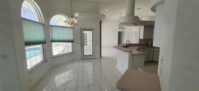 kitchen featuring sink, a high ceiling, a notable chandelier, decorative light fixtures, and kitchen peninsula