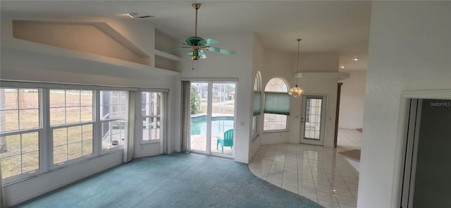 doorway with light tile patterned floors, high vaulted ceiling, and ceiling fan