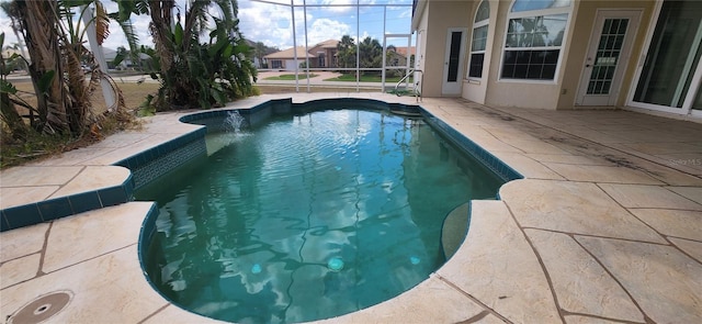 view of pool with a patio and glass enclosure