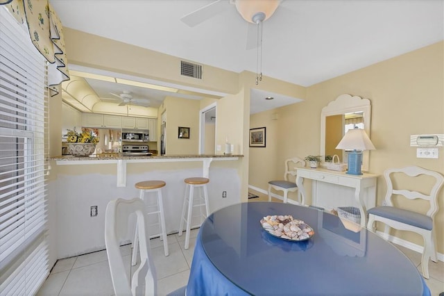 tiled dining area featuring ceiling fan