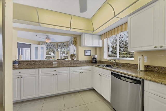 kitchen with stainless steel dishwasher, ceiling fan, white cabinetry, dark stone countertops, and sink