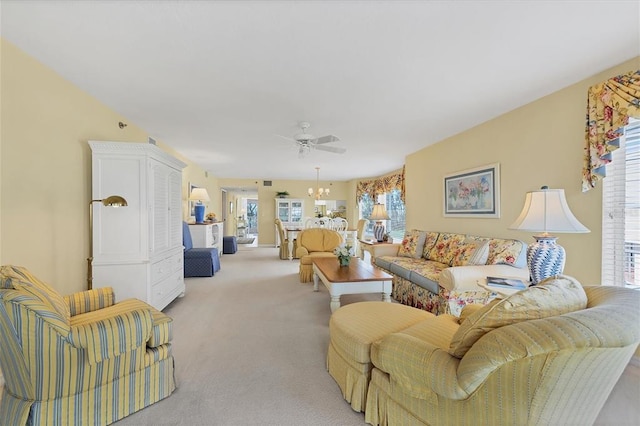 living room featuring light carpet and ceiling fan with notable chandelier