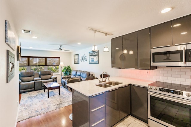 kitchen featuring decorative light fixtures, ceiling fan, range with electric stovetop, light wood-type flooring, and sink