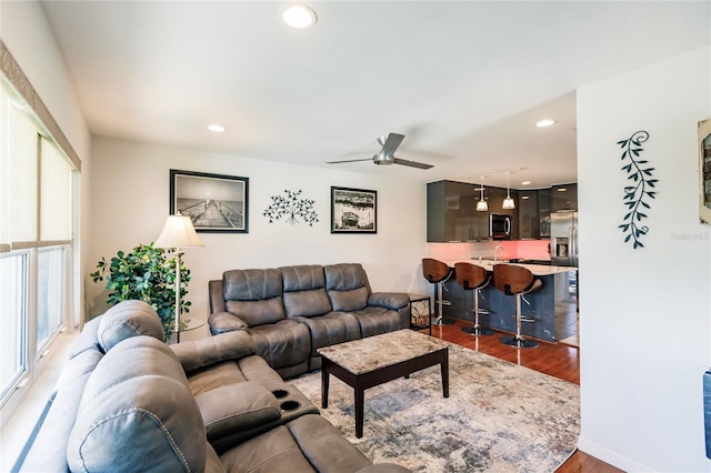 living room with a healthy amount of sunlight, hardwood / wood-style floors, and ceiling fan