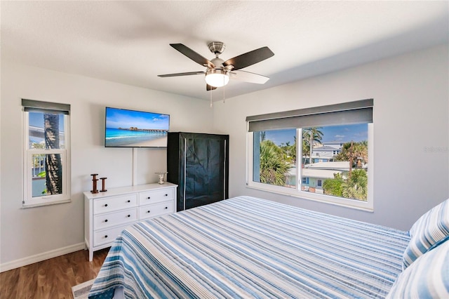 bedroom with dark hardwood / wood-style flooring and ceiling fan