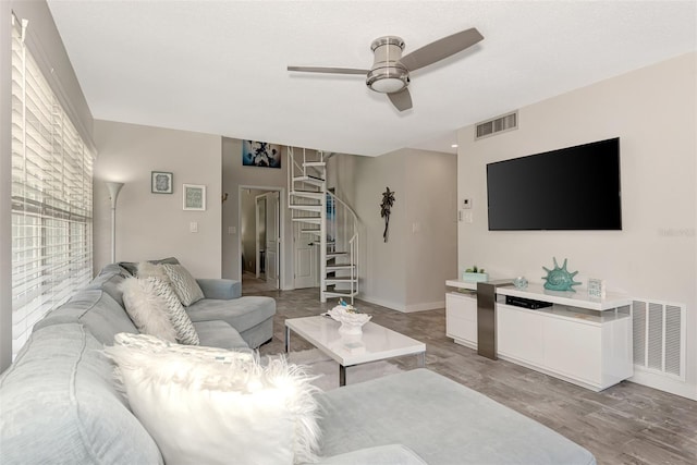 living room featuring light hardwood / wood-style flooring and ceiling fan