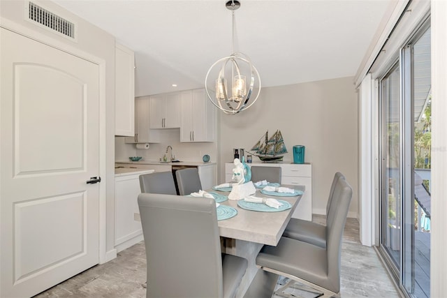 dining space with a chandelier, light hardwood / wood-style flooring, and sink