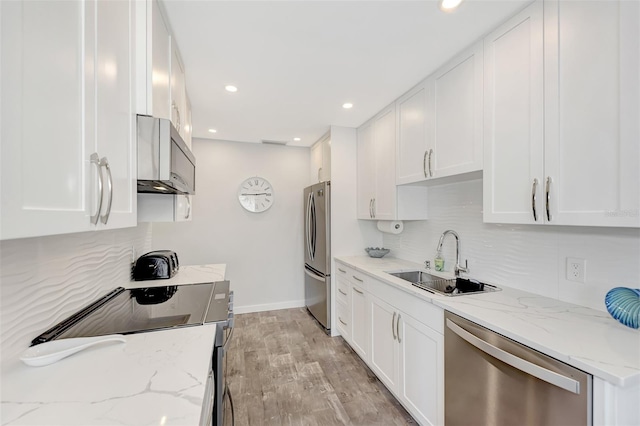 kitchen featuring light hardwood / wood-style floors, sink, stainless steel appliances, white cabinets, and tasteful backsplash