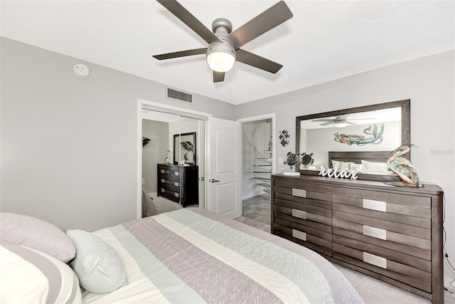 carpeted bedroom featuring a textured ceiling, a closet, and ceiling fan