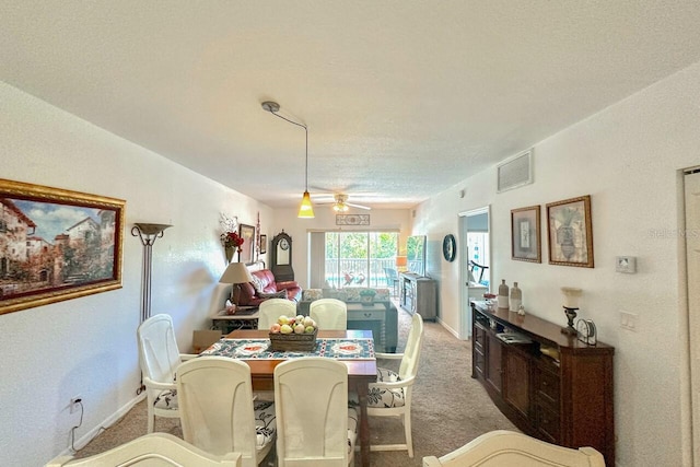 carpeted dining room featuring a textured ceiling and ceiling fan