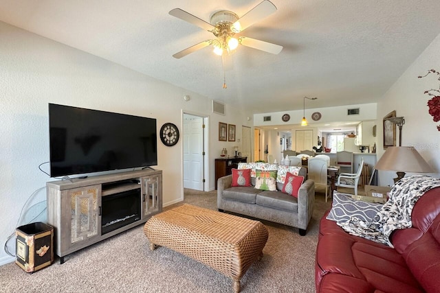 carpeted living room featuring a textured ceiling and ceiling fan