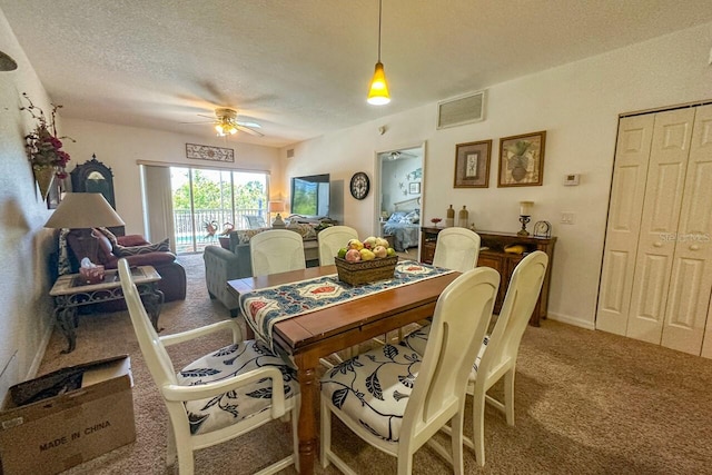 carpeted dining space featuring a textured ceiling and ceiling fan