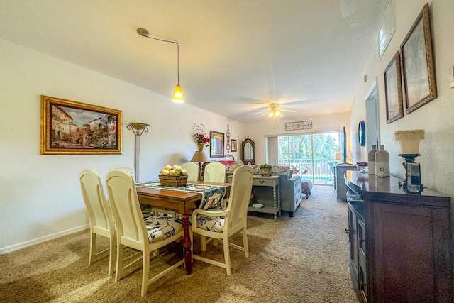 carpeted dining room with ceiling fan