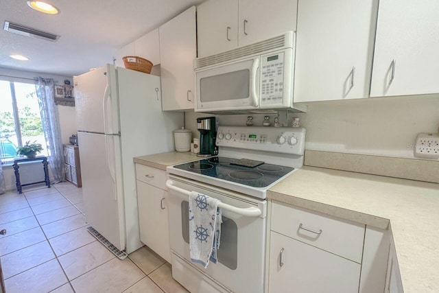 kitchen featuring white appliances, white cabinetry, and light tile floors