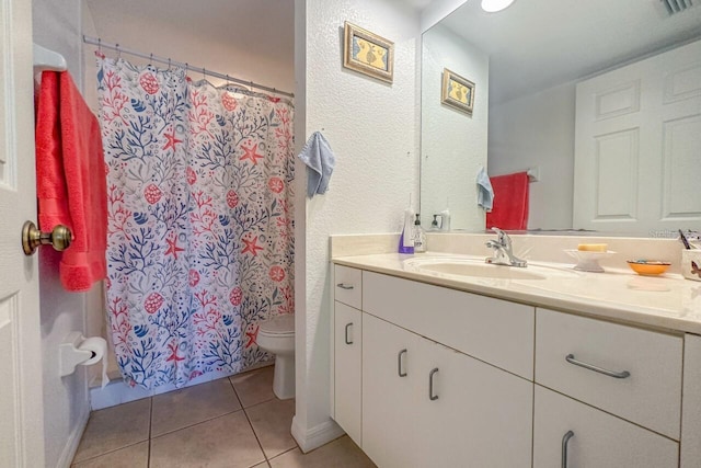 bathroom with toilet, tile floors, and vanity