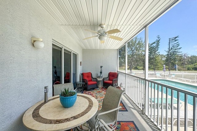 balcony featuring a fenced in pool and ceiling fan