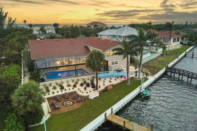 aerial view at dusk featuring a water view