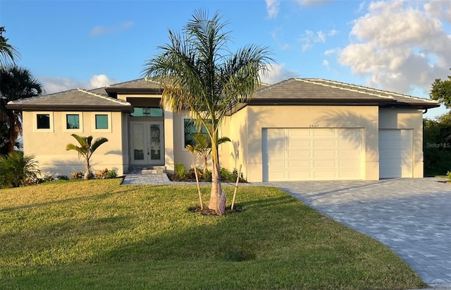 view of front of house with french doors, a front yard, and a garage