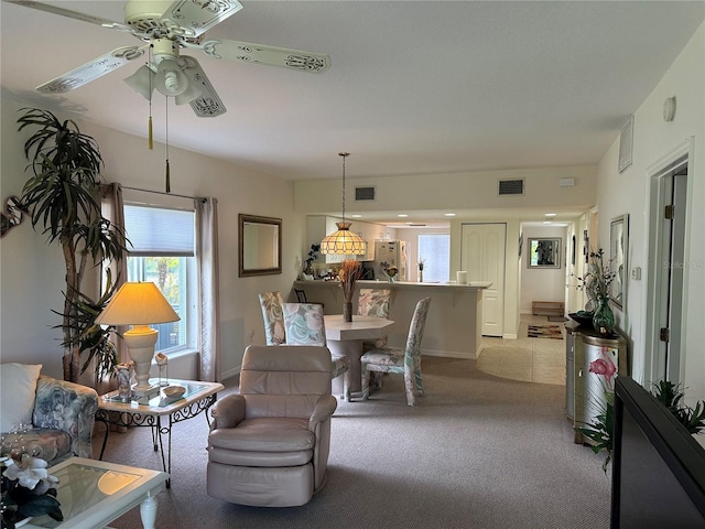 carpeted living room with ceiling fan