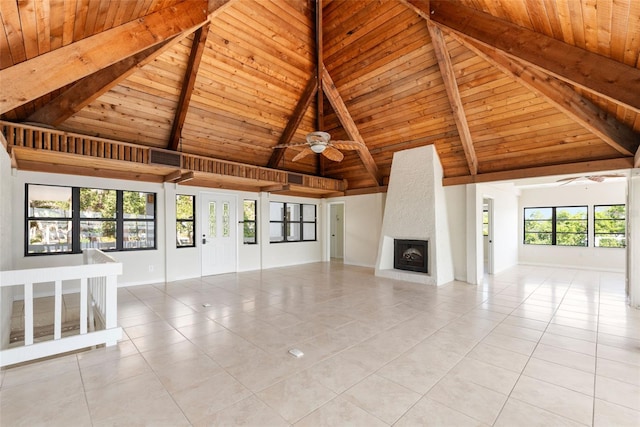 unfurnished living room featuring beamed ceiling, ceiling fan, light tile floors, a fireplace, and wood ceiling