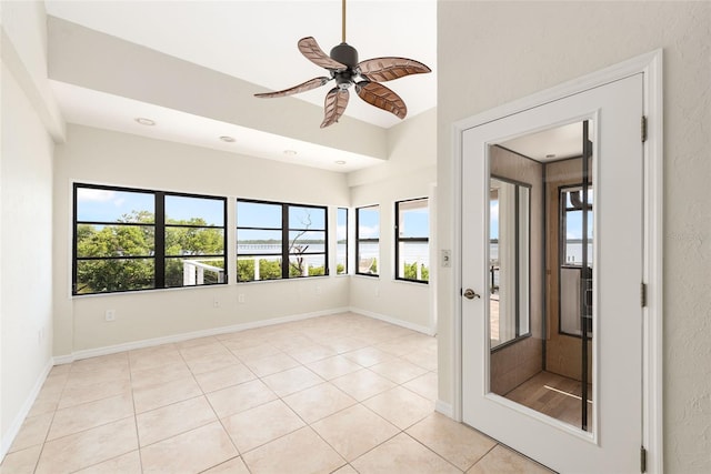 empty room featuring ceiling fan and light tile flooring