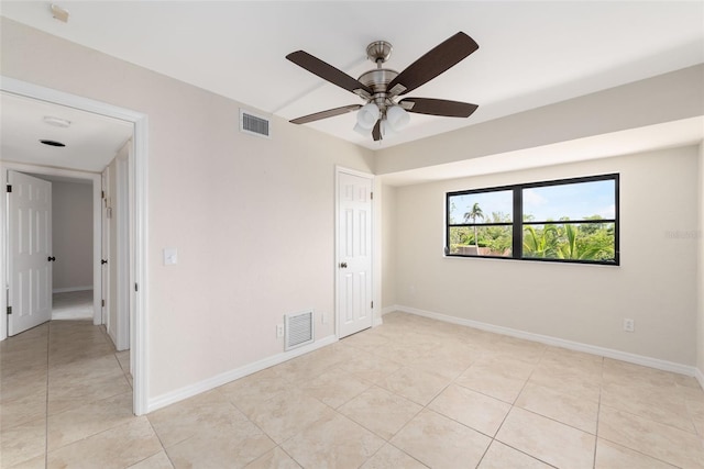 tiled spare room featuring ceiling fan