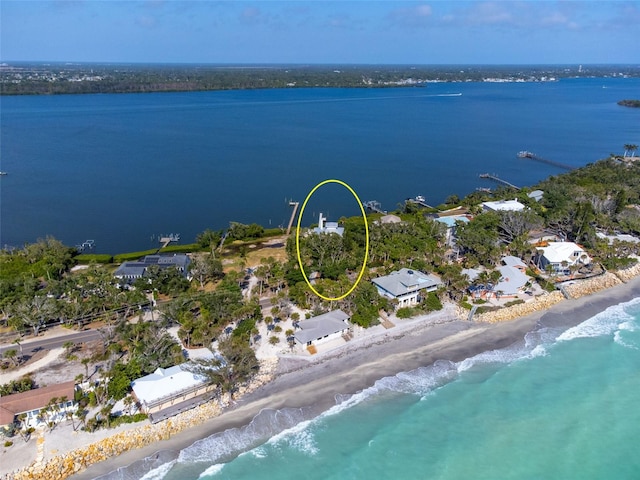 drone / aerial view with a water view and a beach view