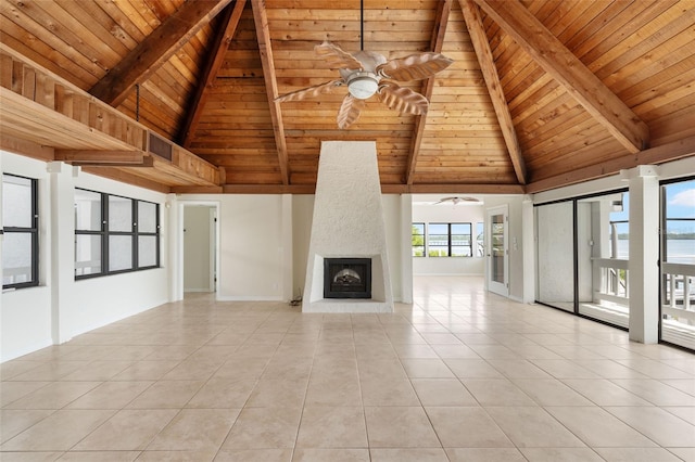 unfurnished living room featuring high vaulted ceiling, beamed ceiling, wooden ceiling, a fireplace, and light tile floors