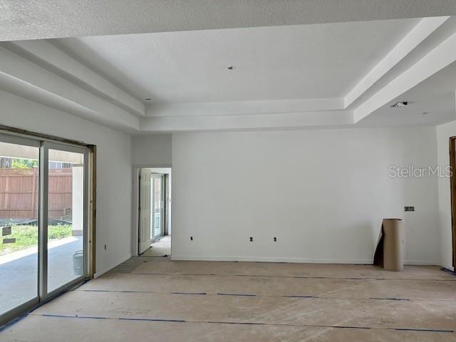 unfurnished room featuring a textured ceiling and a raised ceiling