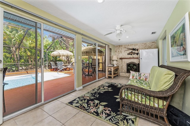 sunroom / solarium featuring a fireplace and ceiling fan