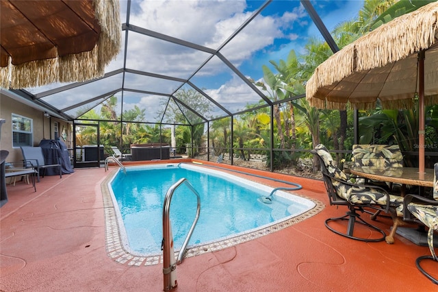 view of swimming pool featuring a patio, a hot tub, and a lanai