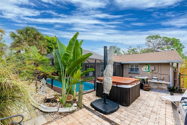 view of patio with a lanai and a swimming pool with hot tub