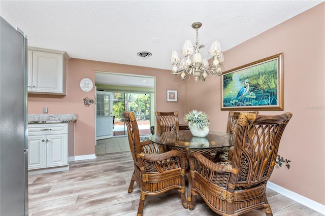 dining area with a chandelier and light hardwood / wood-style flooring