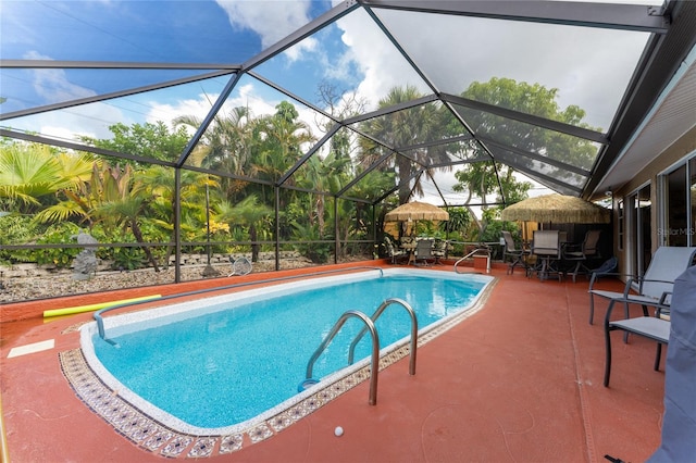 view of swimming pool featuring glass enclosure and a patio area