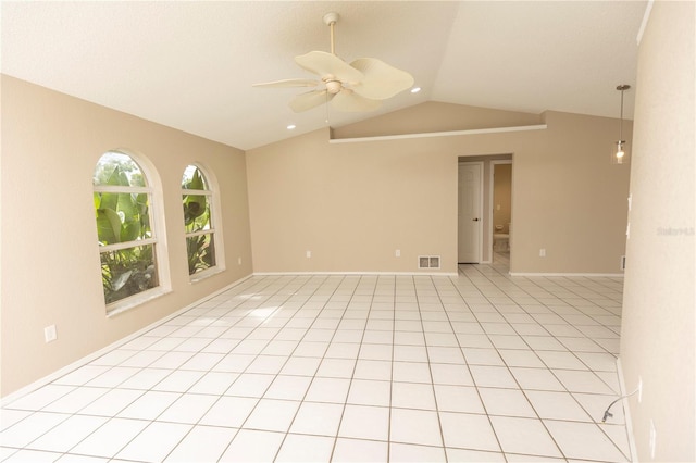 spare room with light tile flooring, ceiling fan, and vaulted ceiling