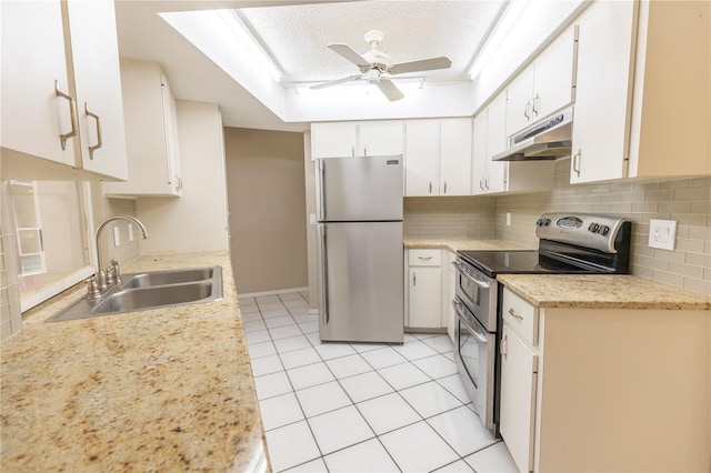 kitchen with appliances with stainless steel finishes, white cabinets, ceiling fan, backsplash, and sink