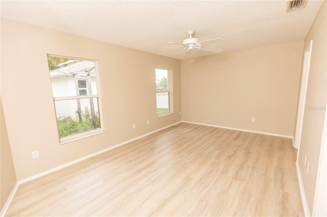 spare room with a textured ceiling, ceiling fan, and light wood-type flooring