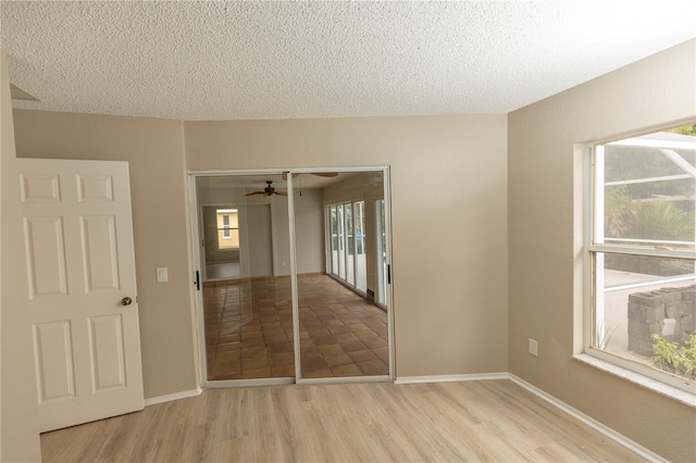 unfurnished bedroom featuring light tile flooring, a closet, and a textured ceiling