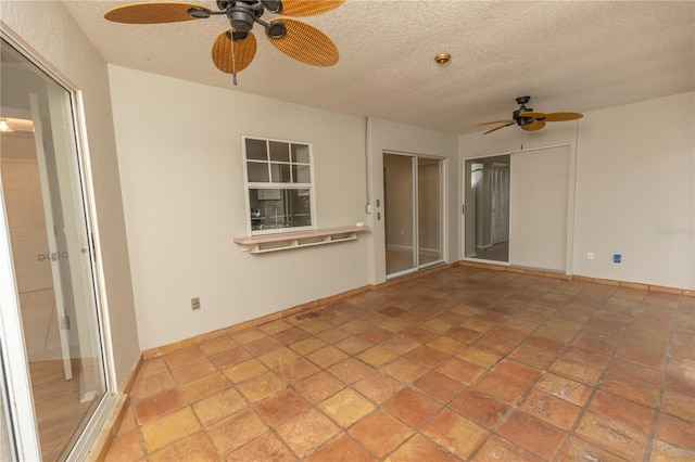 tiled empty room featuring a textured ceiling and ceiling fan