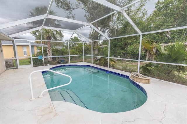 view of pool featuring glass enclosure and a patio area