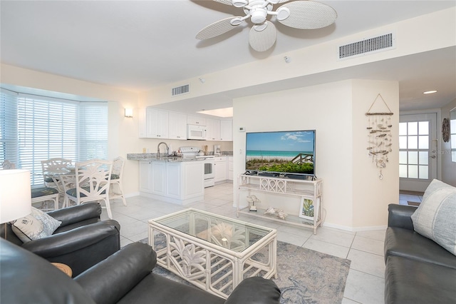 living room with plenty of natural light, light tile floors, and ceiling fan