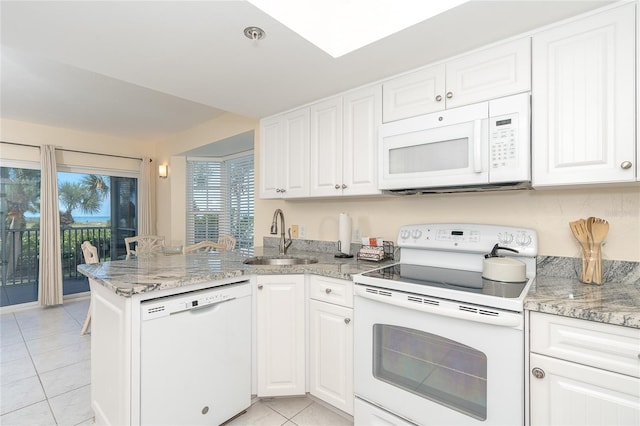 kitchen with white appliances, sink, light tile floors, and light stone counters