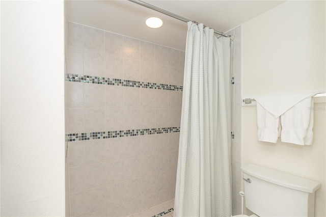 bathroom with a shower with curtain and toilet