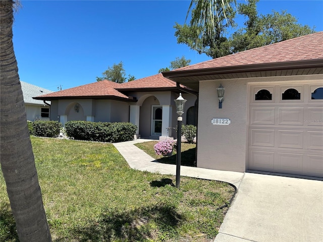 view of front of home with a garage and a front lawn