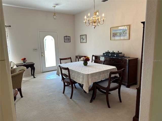 carpeted dining area featuring a notable chandelier