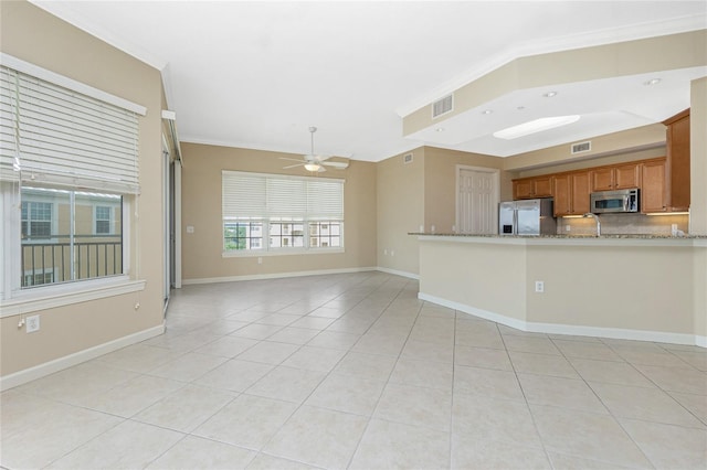 kitchen featuring light tile floors, appliances with stainless steel finishes, light stone counters, and ceiling fan