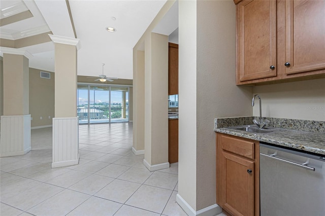 kitchen featuring ceiling fan, light tile flooring, decorative columns, dark stone counters, and stainless steel dishwasher