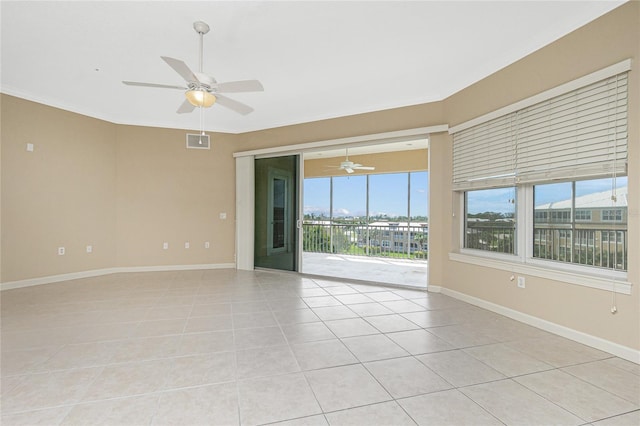 tiled spare room featuring ceiling fan and a wealth of natural light