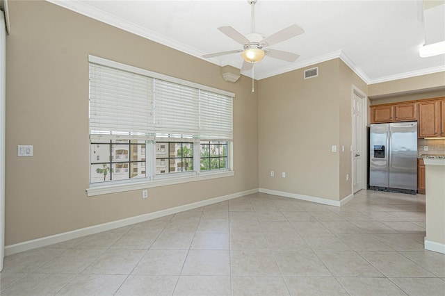 unfurnished room featuring light tile floors, ceiling fan, and ornamental molding