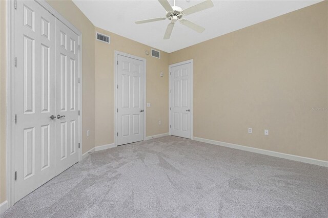 unfurnished bedroom with light colored carpet and ceiling fan